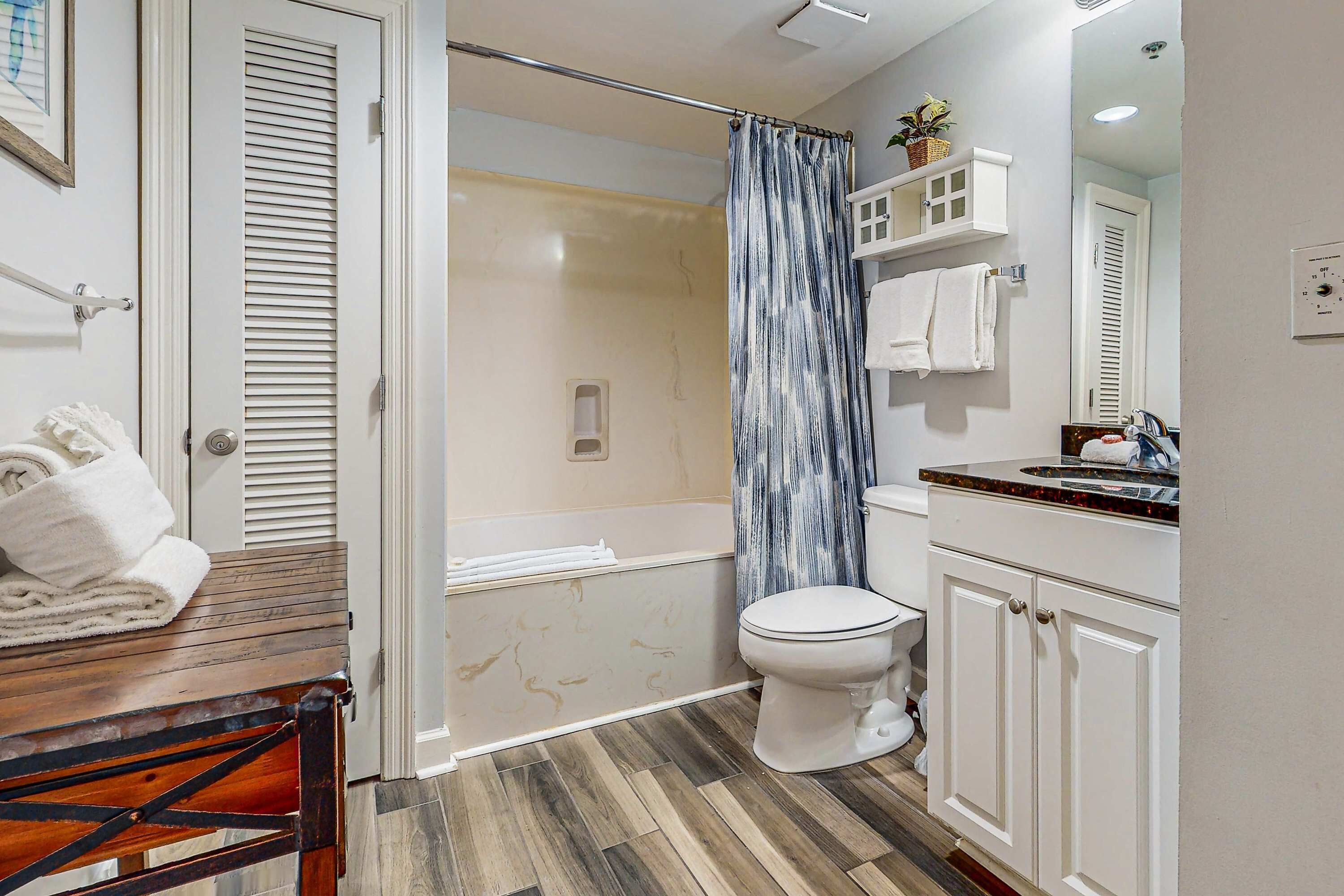 A bathroom with a shower, toilet, and sink.