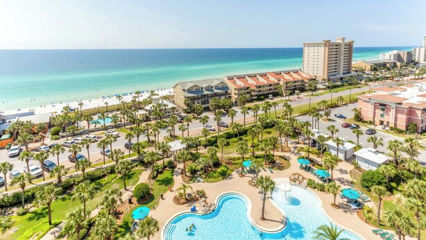 A resort with a pool area, palm trees, and a beach view. - Spacious penthouse condo and private balcony, shared pool&fitness, beach access (Destin)
