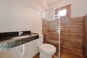 A bathroom with a marble sink, white toilet, and a glass shower enclosure. - The Point Bungalow on the Sand in Fortim By Carpediem (Fortim)