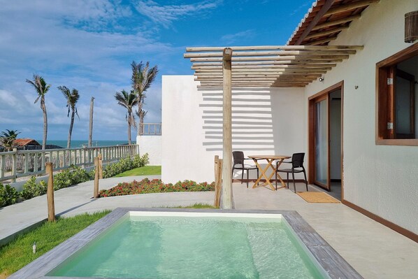 A pool area with a pergola, outdoor seating, and a view of the sea. - The Point Bungalow on the Sand in Fortim By Carpediem (Fortim)