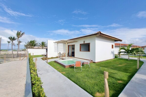 Una casa moderna con piscina, patio y césped cuidado.