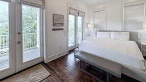 Un dormitorio con cama, ventilador de techo y vista por la puerta.