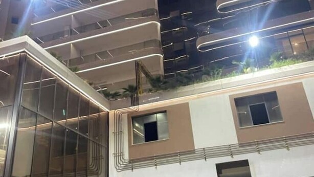 A modern building with multiple balconies, large windows, and a glass facade. - Honeycomb apartment (Béjaïa)