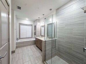 A modern bathroom with a glass shower enclosure, a bathtub, and a vanity with a mirror. - Pool-view condo with on-site pool, hot tub, roof deck, gym, & balcony (Inlet Beach)