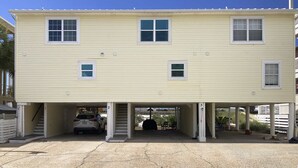 Un bâtiment à deux étages doté d’un garage et d’un espace de stationnement couvert.