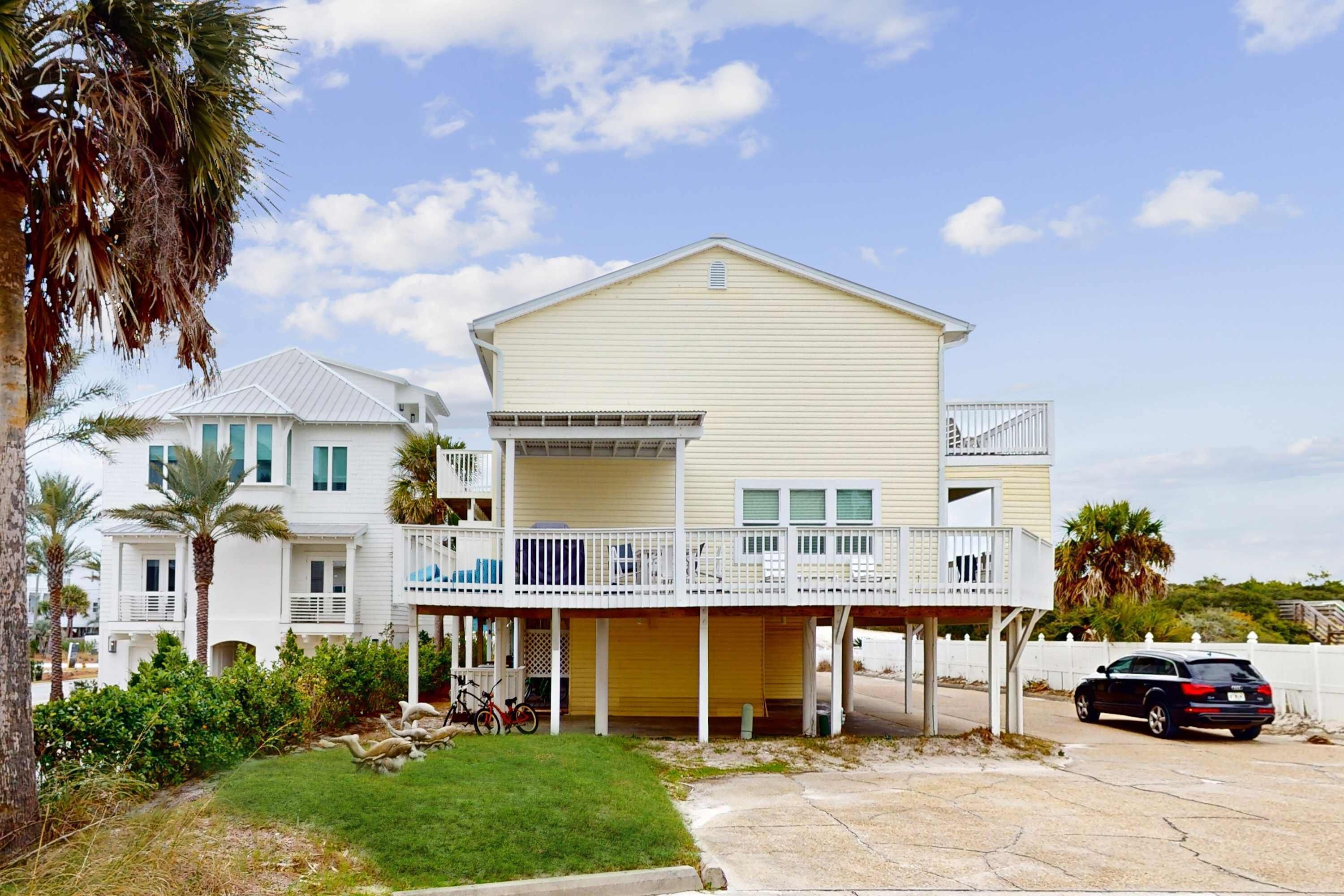 A two-story house with a balcony and a covered porch.