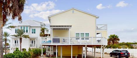 A two-story house with a balcony and a covered porch.
