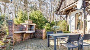 A patio with a brick oven, outdoor seating, and a wooden deck. - Apartment B with Private Terrace, Garden and Wi-Fi (Klausdorf)