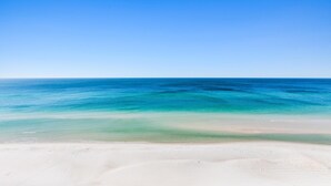 Una playa con agua azul cristalina y una orilla arenosa.