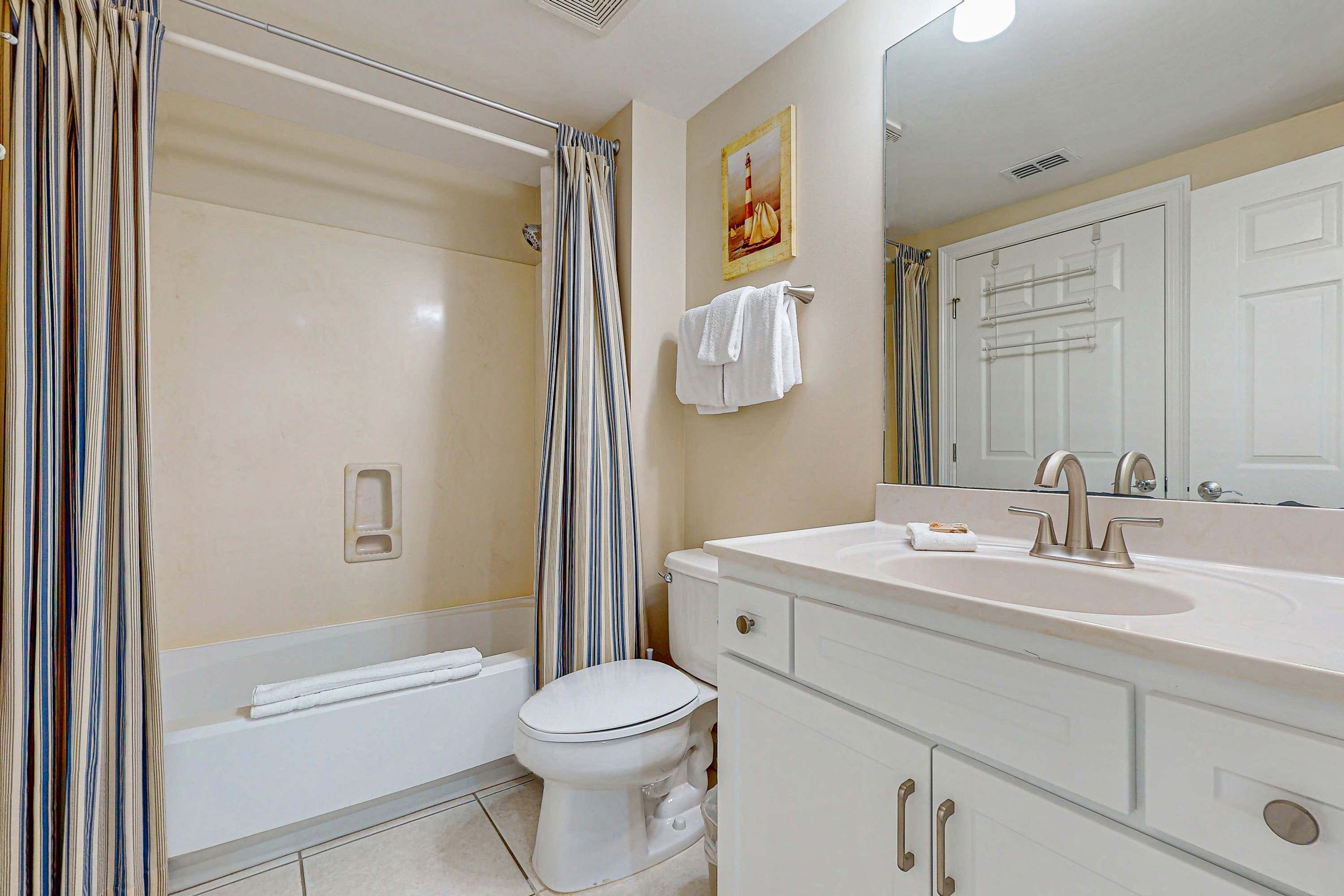 A bathroom with a bathtub, toilet, and sink.