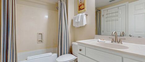 A bathroom with a bathtub, toilet, and sink.
