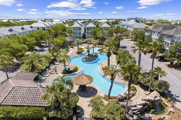 A resort with a swimming pool, palm trees, and a view of the ocean. - Three-Story Home w/Washer/Dryer, Gas Grill, Central A/C, & Shared Pool, Hot Tub (Destin)