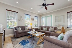 A living room with a sectional sofa, a coffee table, and a ceiling fan. - Three-Story Home w/Washer/Dryer, Gas Grill, Central A/C, & Shared Pool, Hot Tub (Destin)