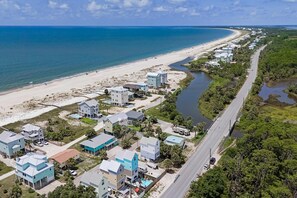 An aerial view of a coastal residential area with houses, a beach, and a river. - Dog-friendly Private home with gulf view, golf cart and easy beach access (Port St. Joe)