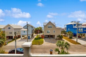A residential neighborhood with single-story houses, a clear sky, and a parked car. - Dog-friendly Private home with gulf view, golf cart and easy beach access (Port St. Joe)