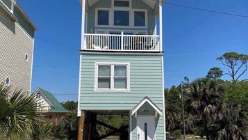 A two-story building with a balcony, a front door, and a small porch.