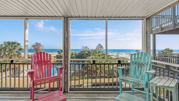 A covered deck with two Adirondack chairs facing a beach view. - Beachfront home with screened porch with boardwalk access to pool (Cape San Blas)