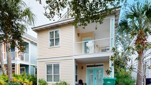 A two-story building with a balcony on the second floor, a front door, and a green trash bin. - Large, Open Home, Shared Pool, Bike or Walk to the Gulf (Destin)
