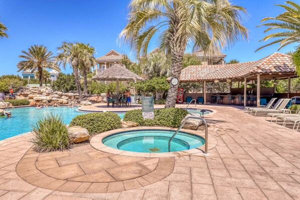 A pool area with a hot tub, lounge chairs, and a sign indicating no children under 12 allowed. - Dog-friendly home near beach with pool access, two balconies, wet bar, & WD (Destin)