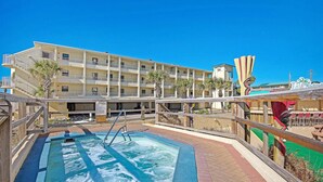 Un hôtel doté d’une piscine, de plusieurs balcons et de palmiers.