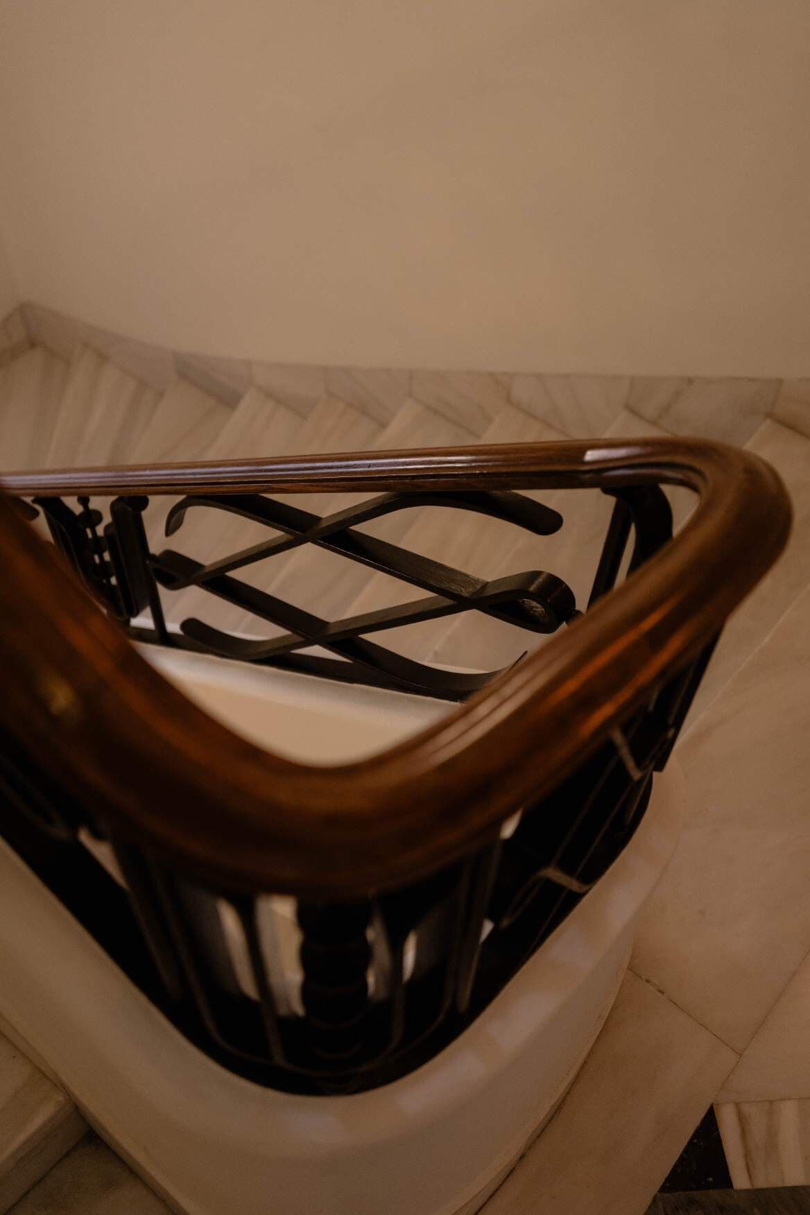 Una escalera de madera con barandilla metálica.