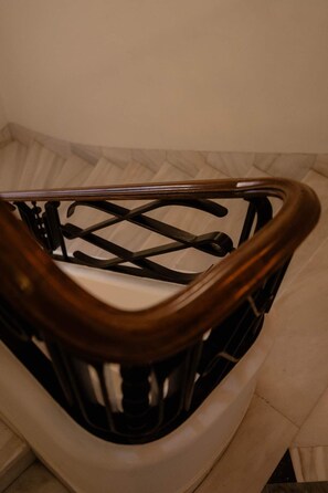 A wooden-framed staircase with a metal handrail. - The Newel Kolonaki (Athens)