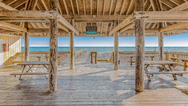 A wooden pier with picnic tables and a sign dedicated to Jerry Voss. - Inviting condo with dock, pool, hot tub & private beach - dog-friendly (Destin)