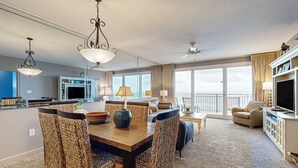 Un salon spacieux avec un coin repas, de grandes fenêtres et un balcon.