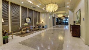 Eine großzügige Lobby mit einer Kandelaber, einer Sitzecke und Blick ins Restaurant.