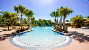 A circular pool with a tiled edge, surrounded by palm trees and lounge chairs, with buildings in the background. - Dog friendly home and casita with pool plus beach access, central AC, and laundry (Port St. Joe)