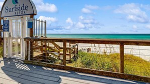A wooden boardwalk leading to a beach with a sign for Surfside Resort. - Cozy ground-floor condo with private patio, shared pool & beach access (Miramar Beach)