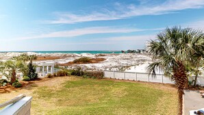 Een kustgezicht met een zandstrand, een palmboom en een witte prieel.