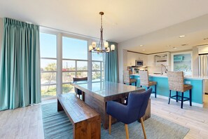 Eine moderne Küche mit einer großen Kochinsel, einer Holzbank und blauen Stühlen.