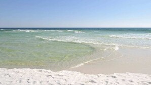 Una spiaggia con acque cristalline e sabbia bianca.