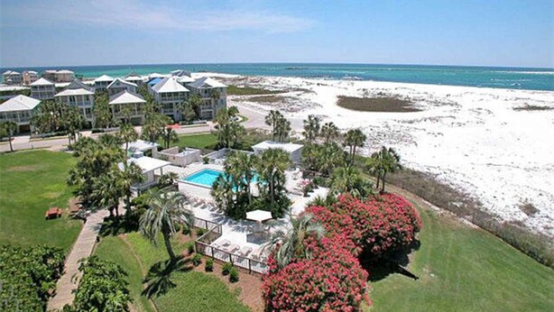 Un resort con diversi edifici, una piscina e una spiaggia.