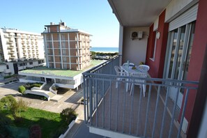 Un balcon donnant sur un ensemble d’immeubles et la mer.