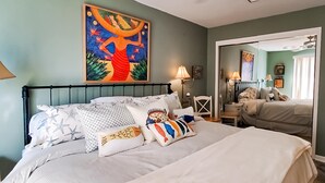 A bedroom with a bed, pillows, a nightstand, a lamp, and a painting on the wall. - Beachfront Condo, gorgeous views, beach access & close to everything (Destin)