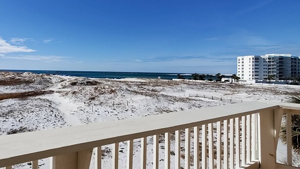 A beach view with a white building in the background. - Beachfront Condo, gorgeous views, beach access & close to everything (Destin)