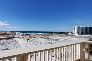 Une vue sur la plage avec un bâtiment blanc en arrière-plan.