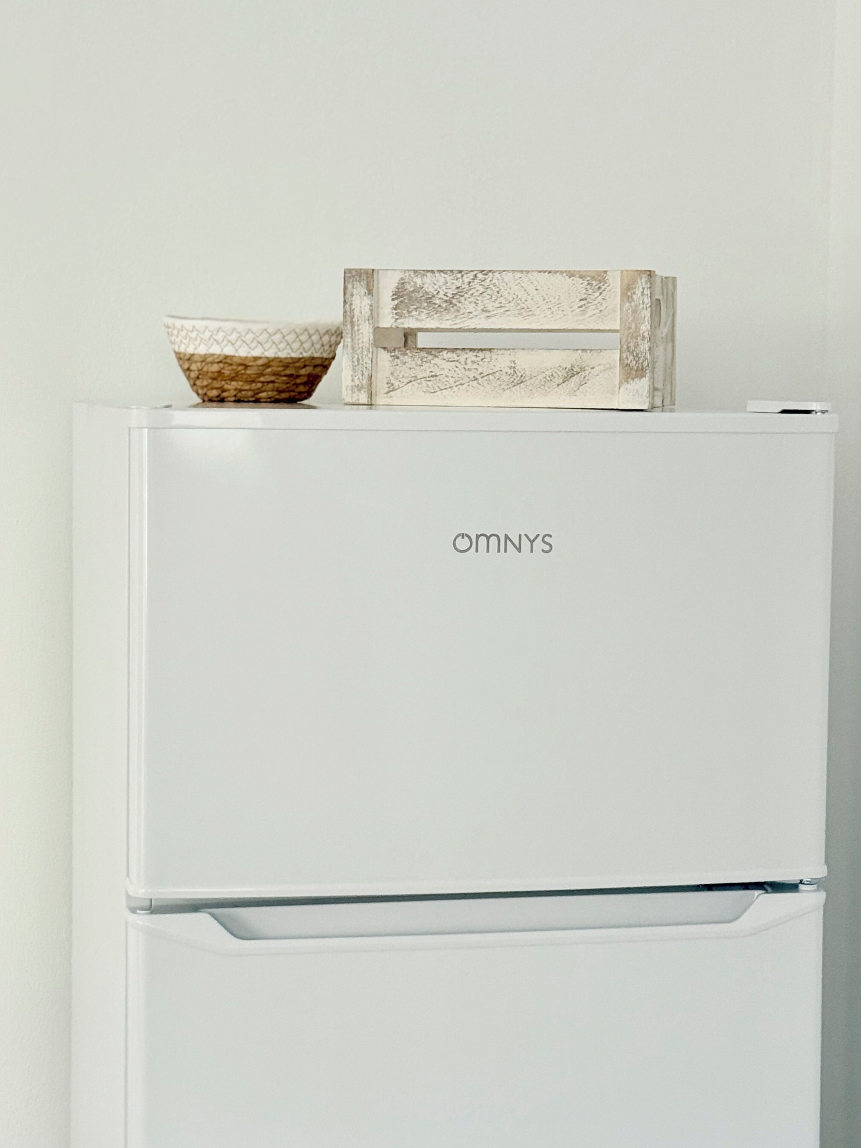 Un réfrigérateur blanc de la marque OmnyS, doté d’une double porte et d’une poignée sur la porte inférieure.