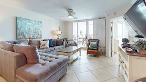 Ein geräumiges Wohnzimmer mit einem großen Ecksofa, einem Couchtisch und einem Essbereich mit einem Korbstuhl und Tisch.