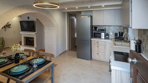 A modern kitchen with a built-in oven, microwave, and stainless steel refrigerator. - Conaleni - Concona Houses (Rethymno)