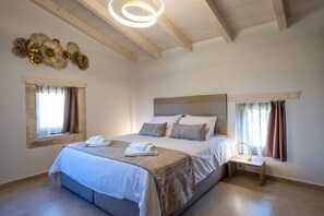 Een slaapkamer met een groot bed, een nachtkastje met spiegel en decoratieve wanddecoratie.