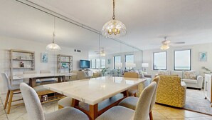 Un salón amplio con una gran mesa de comedor, asientos cómodos e iluminación moderna.