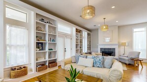 Amplia sala de estar con un sofá color beige, una mesa de centro de madera y una chimenea.