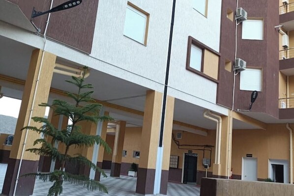 A multi-story building with a central atrium, columns, and a staircase.