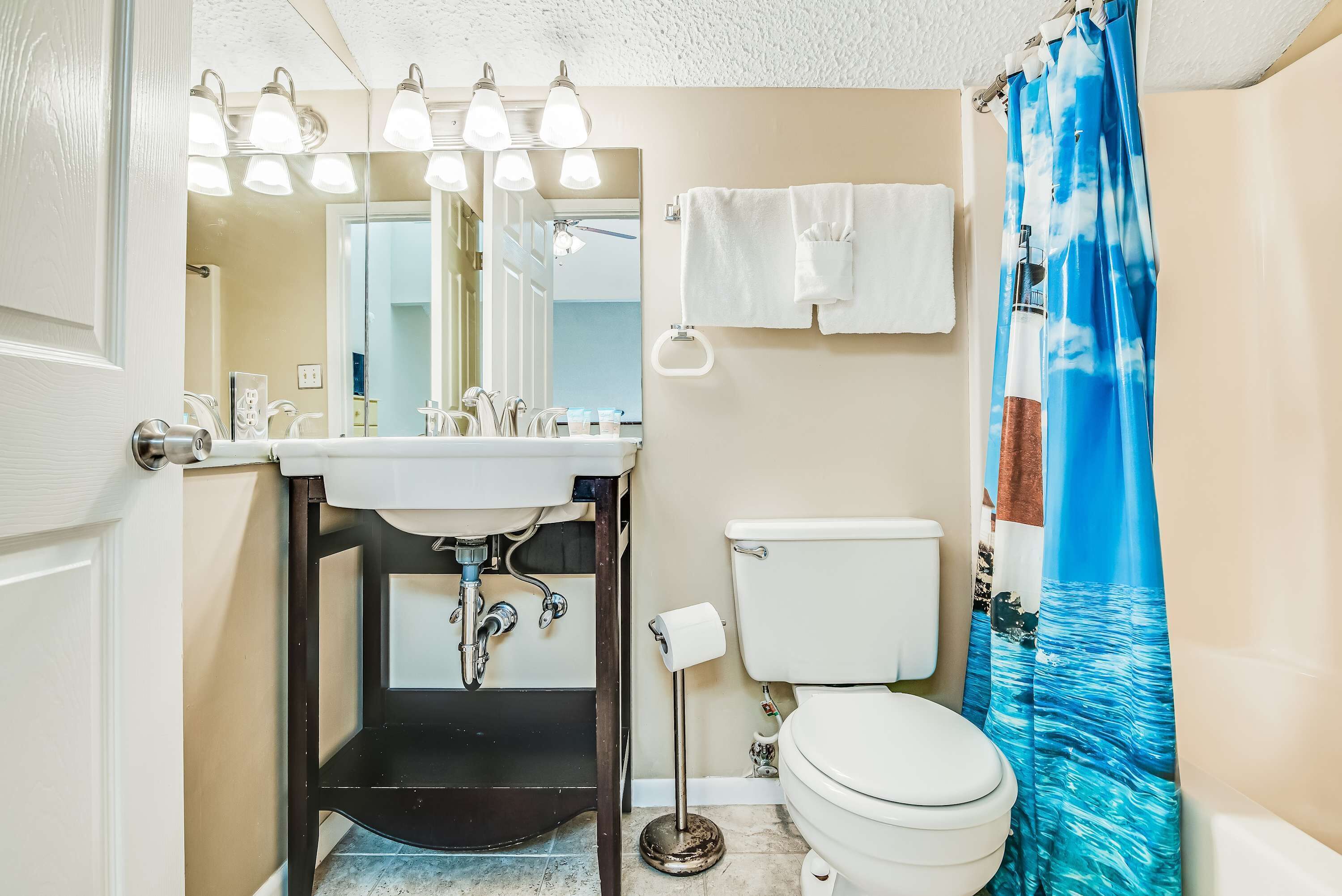 A bathroom with a sink, mirror, and toilet.