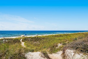 A beach with a clear view of the ocean, a sandy path, and some beachgoers. - Multi-Level Seaside Condo w/ Easy Beach Access, Pool, & Water Views (Panama City Beach)