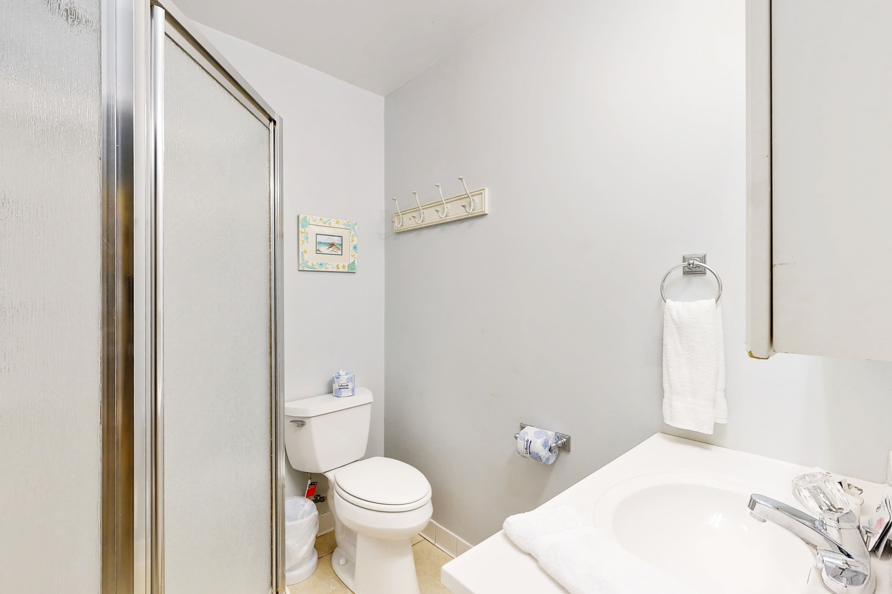A bathroom with a toilet, sink, and a towel rack.