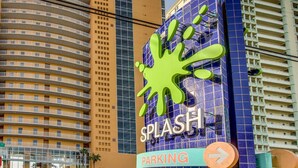 A building with a large 'Splash' sign and a parking direction sign. - Gulf-front condo with pool, hot tub, balcony, & complimentary beach service (Panama City Beach)
